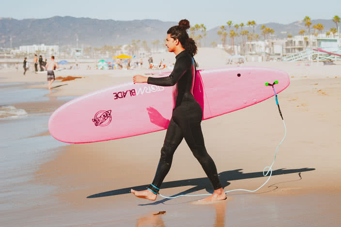 Kid Walking into Ocean with Pink Surfboard