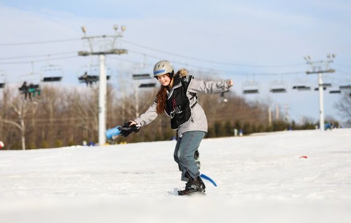 Chill youth snowboarding and sticking his arms up in happiness and success