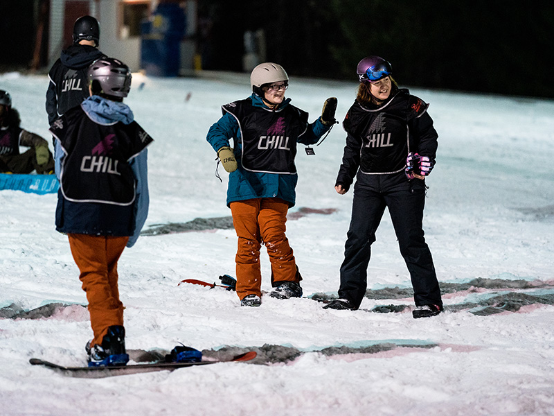 A youth and mentor snowboarding.