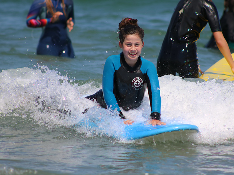 A Chill youth smiling while riding a wave.