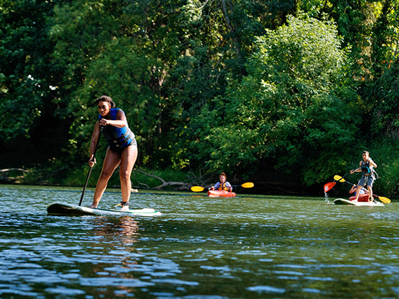 Chill youth paddling on a stand up paddleboard.