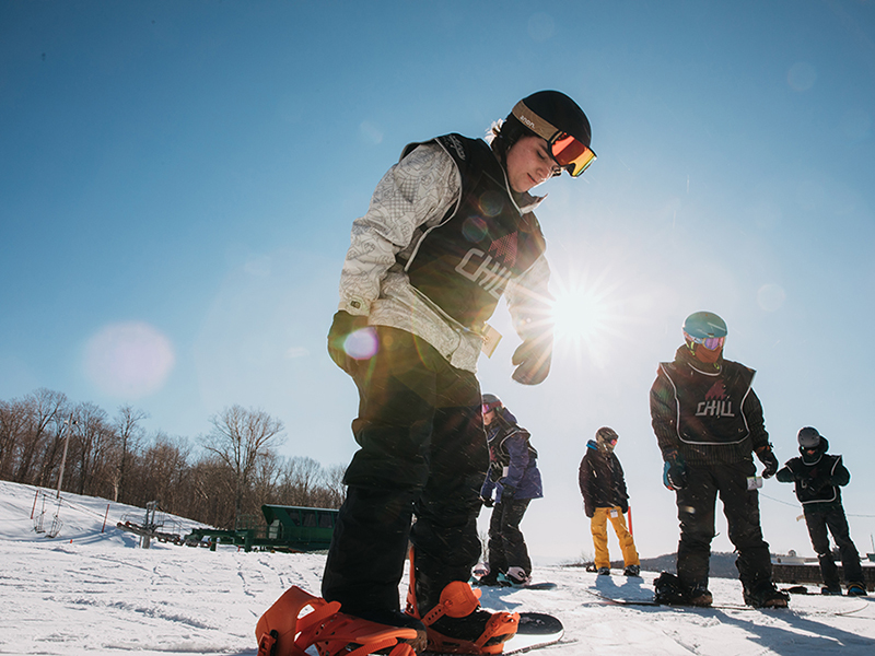 Chill youth getting ready to snowboard.