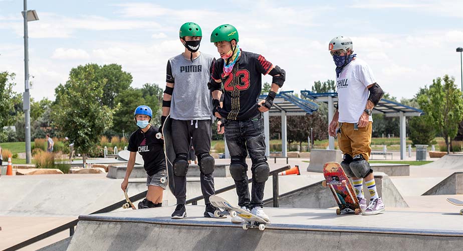 Chill youth standing on top of a ramp looking down at the skatepark