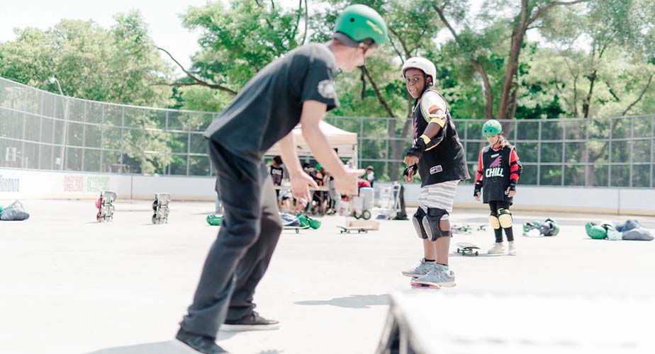 Chill mentor waiting by a ramp for a chill youth to come try a trick