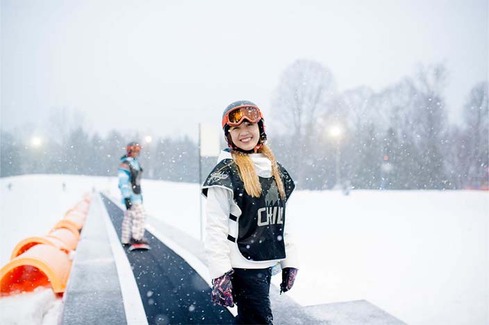 Chill youth smiling at the camera on her way up the lift