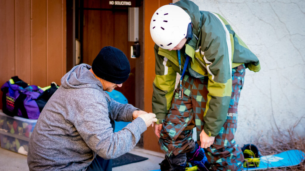 Peer mentor helping a Chill youth get geared up.