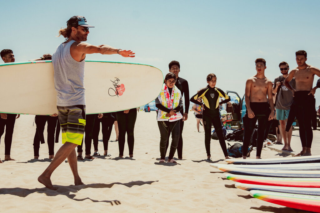 Chill group receiving surf instruction on the beach