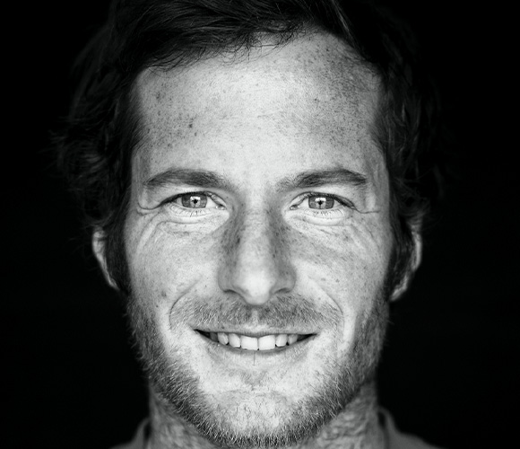 Smiling male posed at camera, photo in black and white