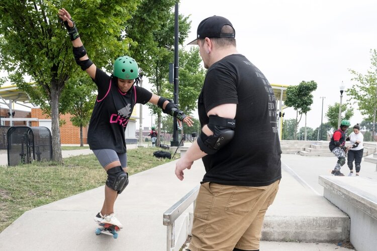 Youth skating with an instructor.