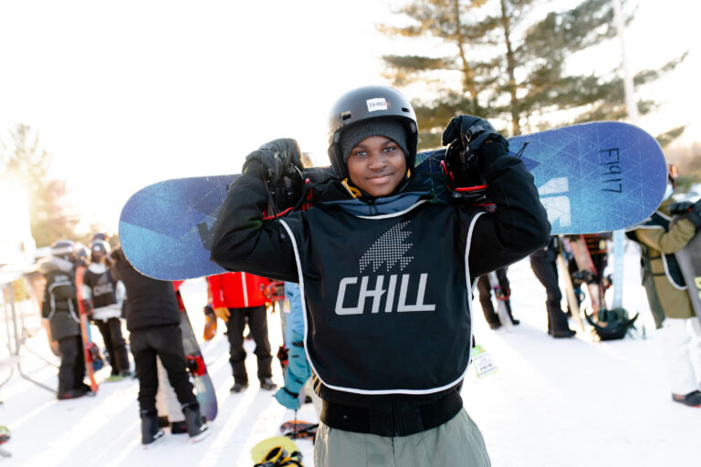 Chill youth holding a snowboard.