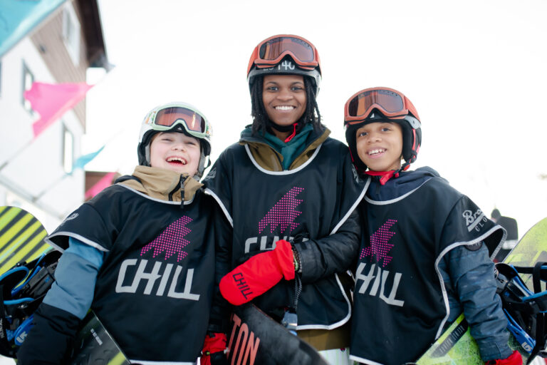 Three Chill snowboard participants posing for a photo in snow gear.